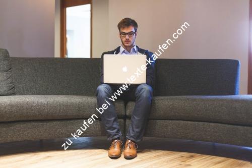 Mann sitzt mit einen Laptop auf dem Sofa