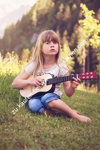 Kind Gitarre spielend Wiese